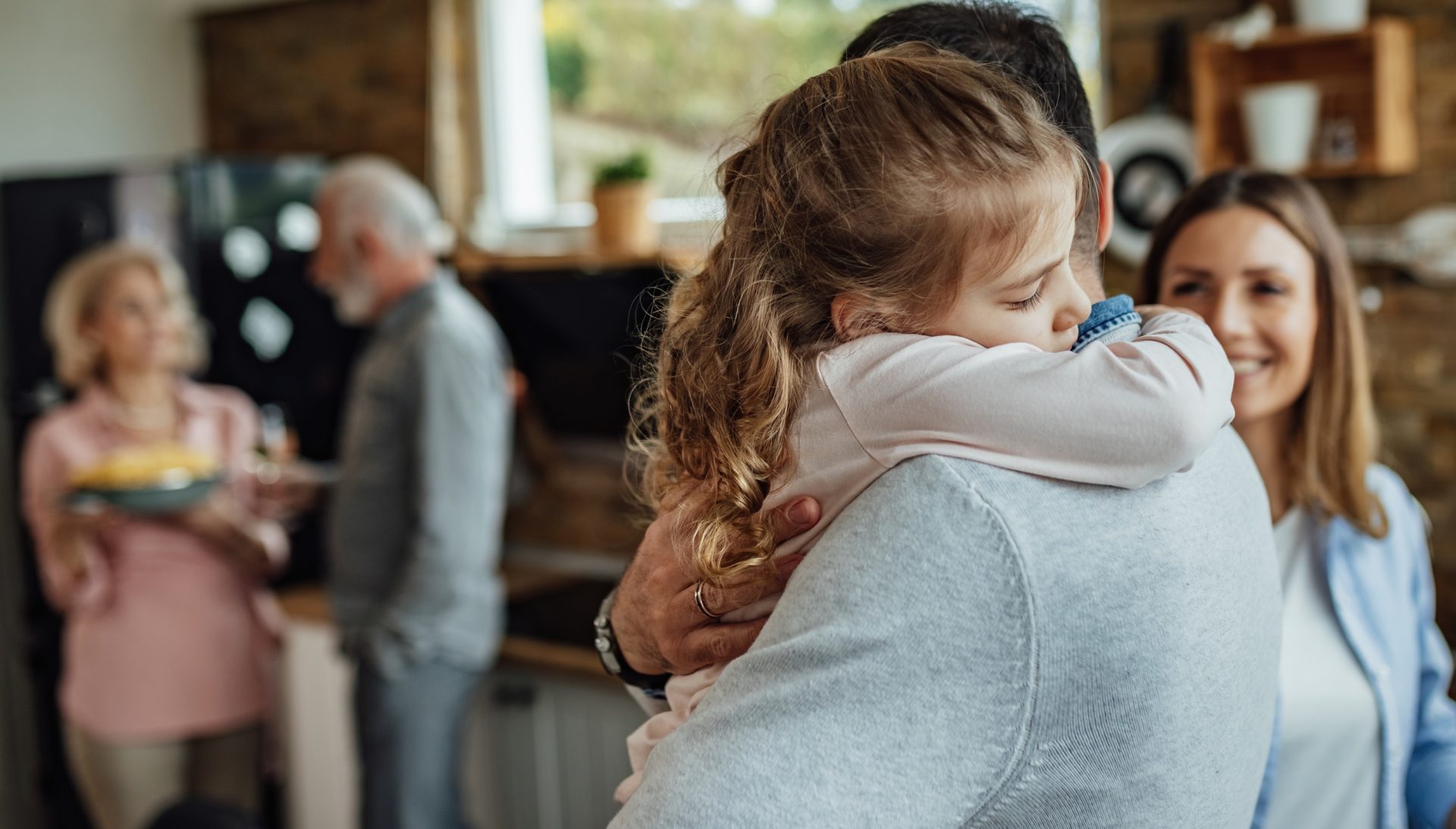 Affectionate daughter embracing her father with eyes closed.